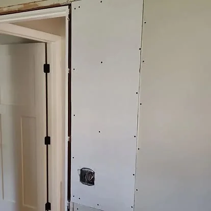 New wallboard installed beside the doorway during the repair